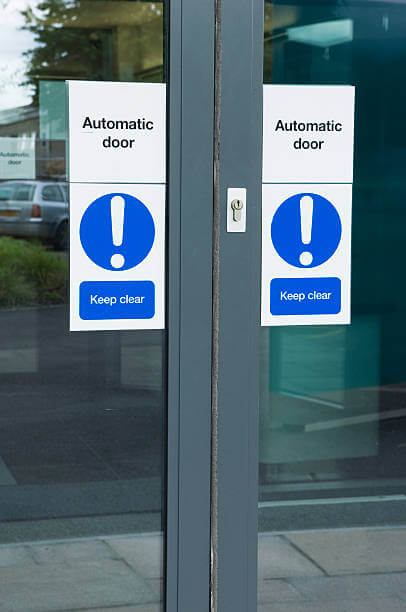 Close Up Of Modern Automatic Office Door With 'Keep Clear' Signs. Close Up Of Modern Automatic Office Door. For Any Automatic Door Installation And Repair In Dc And Md, Call King And Door Lock