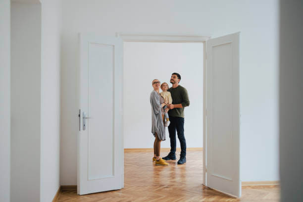 Happy Smiling Family With One Child Standing In New Home On Moving Day. Happy Smiling Family With One Child Standing In New Home On Moving Day With Their Newly Installed Interior Door